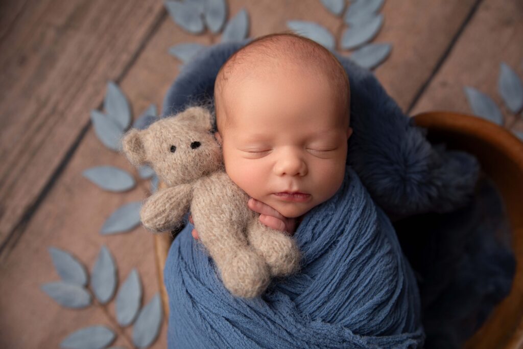 Wrapped newborn baby boy in blue styling during Phoenix in-studio newborn photography.