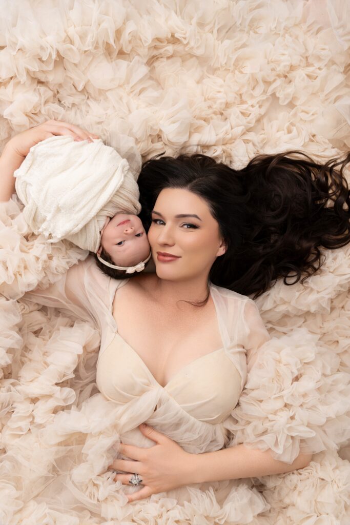 Mother holding newborn baby during elegant Phoenix fine art newborn photography session.