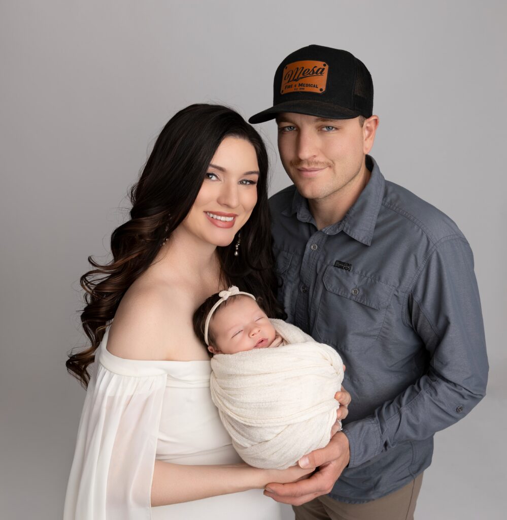 Parents holding newborn baby during Phoenix studio family newborn photography session.